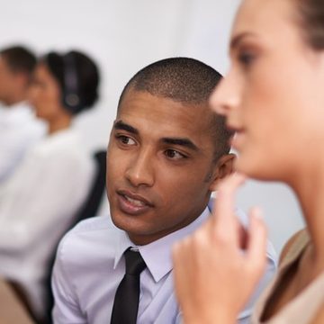 HR consultant in a shirt and tie listening to a colleague in a meeting